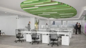 Diseño de oficinas conceptuales con plafones verdes y cubículos de trabajo modernos.