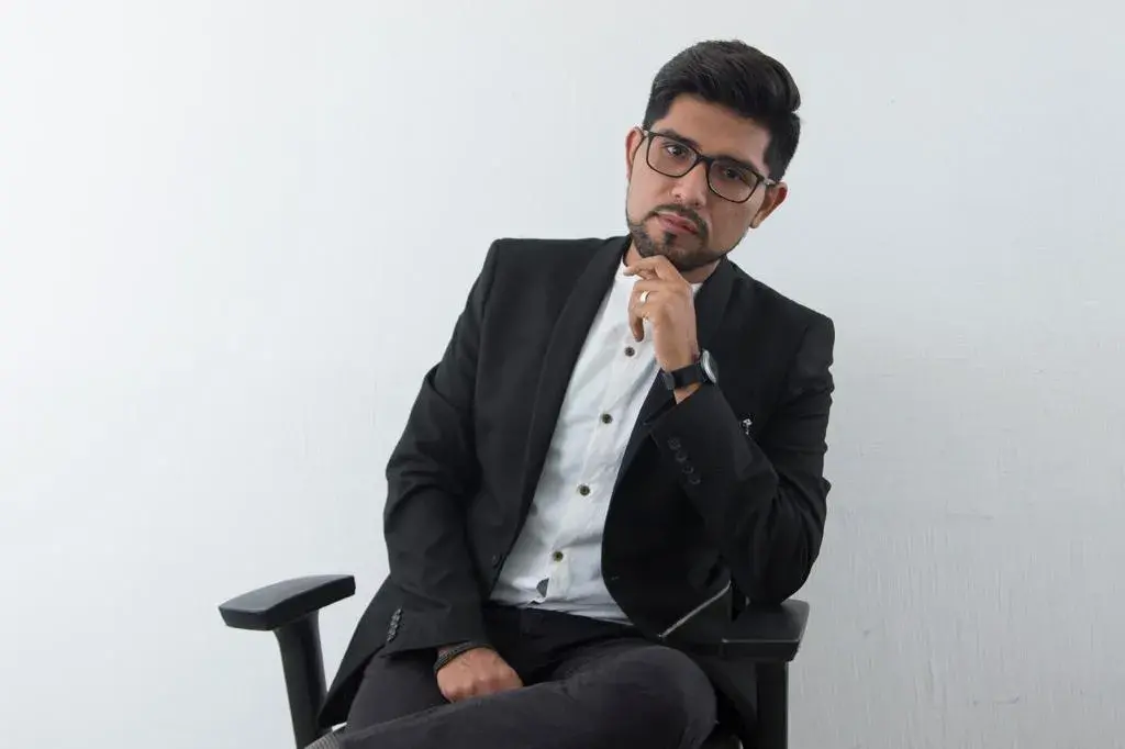 Fotografía de Aldo, arquitecto del equipo de InOut Arquitectura en traje corporativo negro.