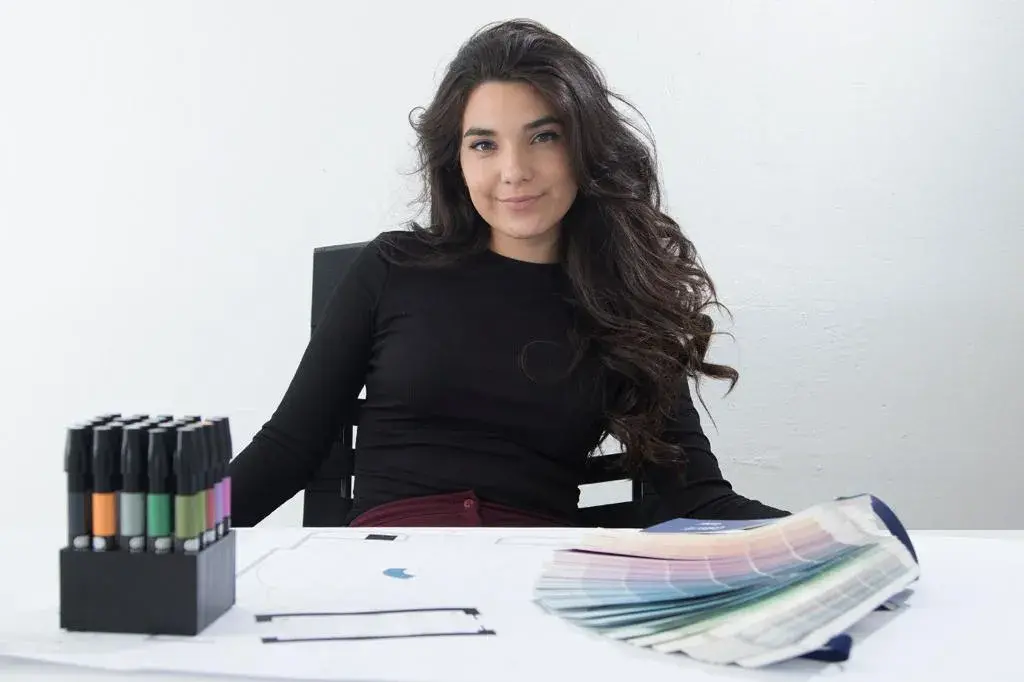 Retrato corporativo de Daniela, diseñadora del equipo de InOut Arquitectura en su escritorio de trabajo.