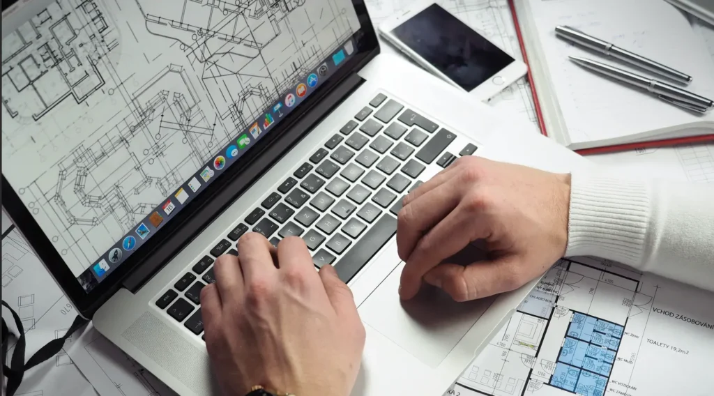 Arquitecto trabajando en plano digital y diseño arquitectónico en una computadora portátil.